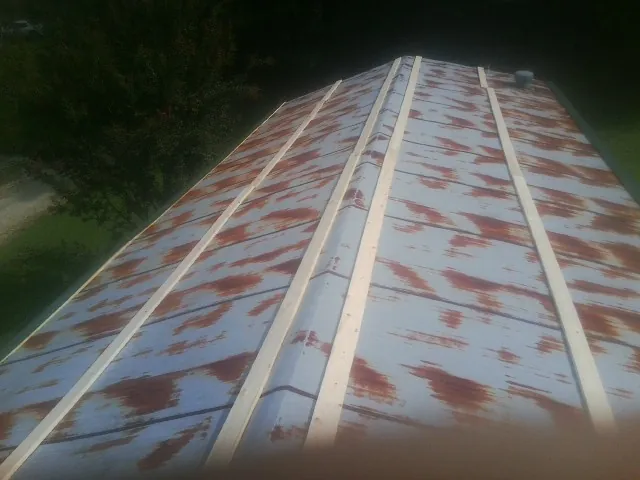 Rusted metal roof panels with new wood purlins before replacement — Storm Damage Roof Repair in Lloyd by Roofing Brothers