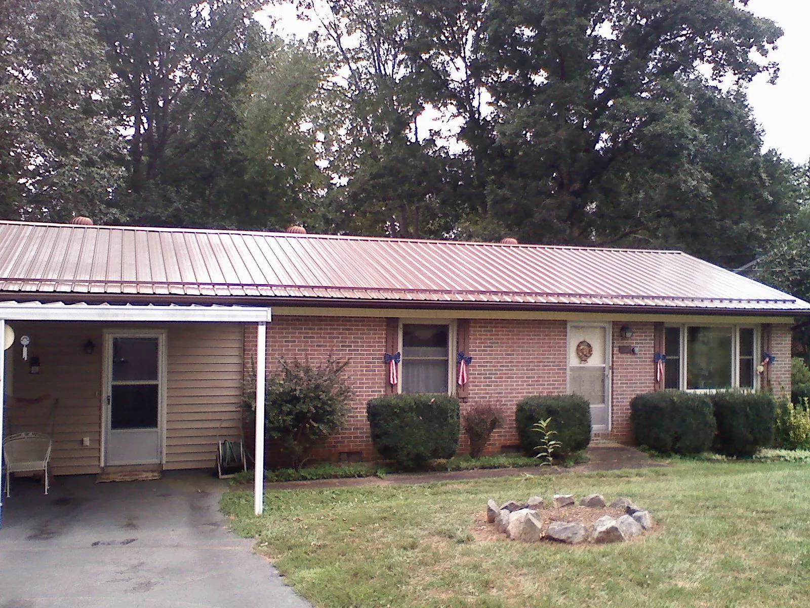 Bronze metal roof and carport on a brick ranch home — Roof Repair work by our crew in Lloyd